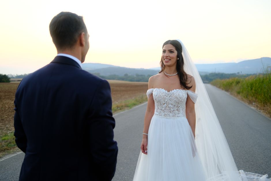 Bride and groom standing together in a beautiful sunset landscape